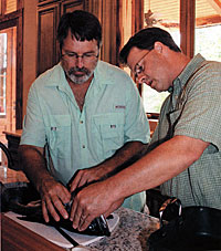 Biologist Bob Lusk and BassPro Shops Dan Hoy dissect the fish, looking for clues into its poor body condition.