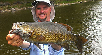 Guide Chad Betts with a chunky Muskegon River smallmouth. Image by bettsguideservice.com