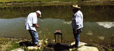 Mike Otto (L) looks over a water control structure, while Mike McDonald (R) explains what it took to build it properly.