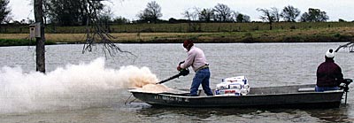A landowner applying powdered gypsum to help increase clarity in his pond.