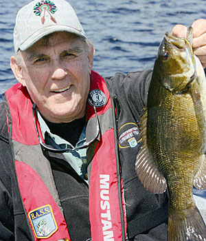 Ray Scott, founder ofB.A.S.S. holds an eggy female smallmouth bass, prime and ready for spawn.